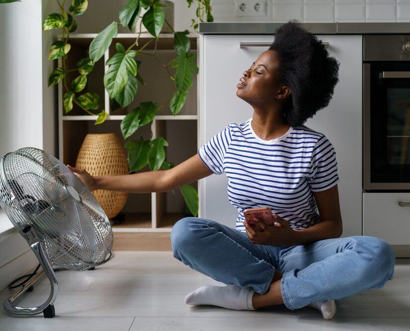 Young,Black,Woman,Sits,On,Floor,With,Smartphone,,Tries,To
